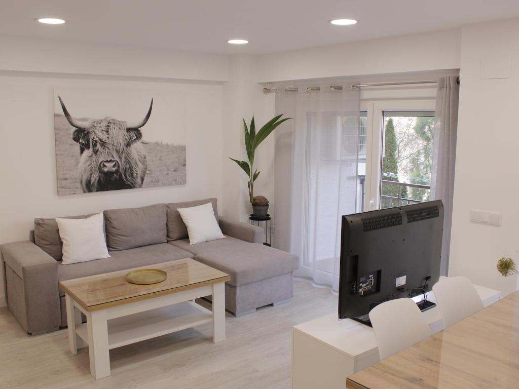 una sala de estar con sofá y una vaca en la pared en Cuenca Home, en Cuenca