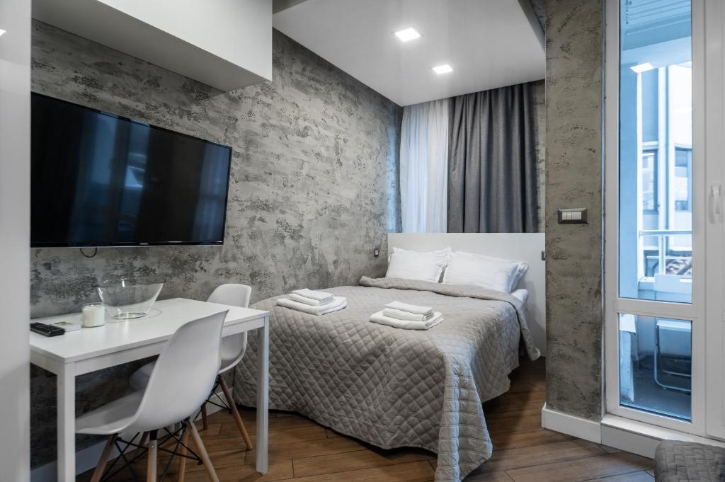 a bedroom with a bed and a table and a tv at Luxury Studio Silver in Sofia