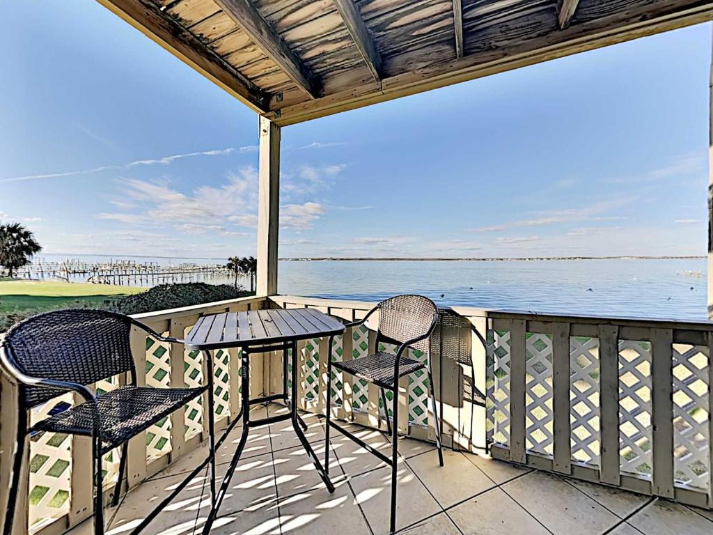 a balcony with a table and chairs and the ocean at Baywatch #B1 in Pensacola Beach