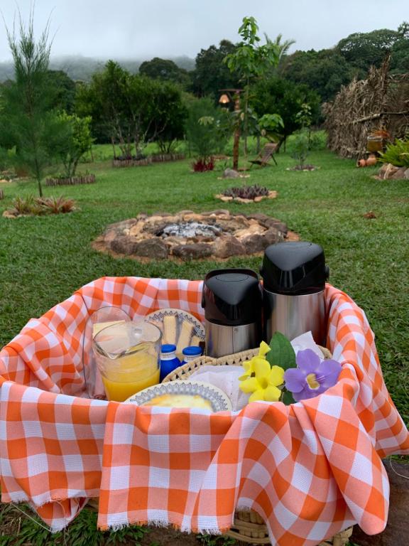 a picnic basket with food and drinks on a blanket at Quinta dos Laranjais Chalés in Viçosa do Ceará