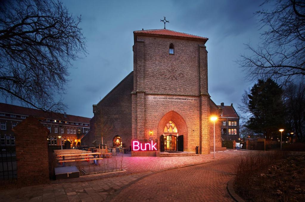 um edifício com um cartaz que lê compra na frente dele em Bunk Hotel Amsterdam em Amsterdã