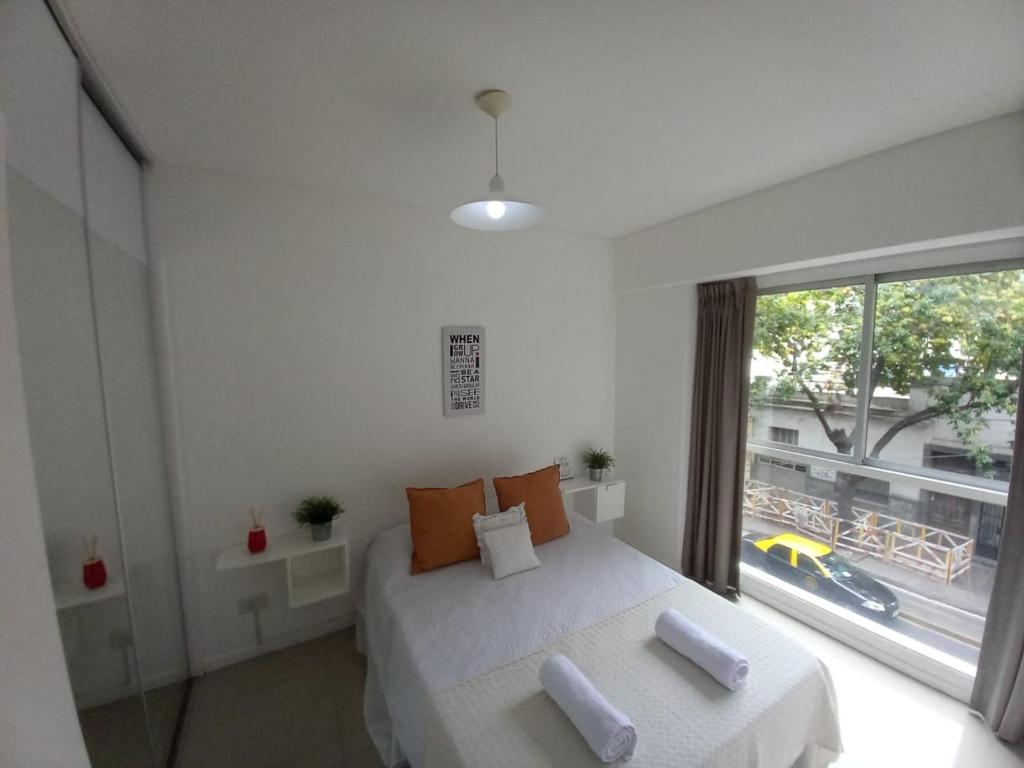 1 dormitorio con cama blanca y ventana grande en Palermo House en Buenos Aires