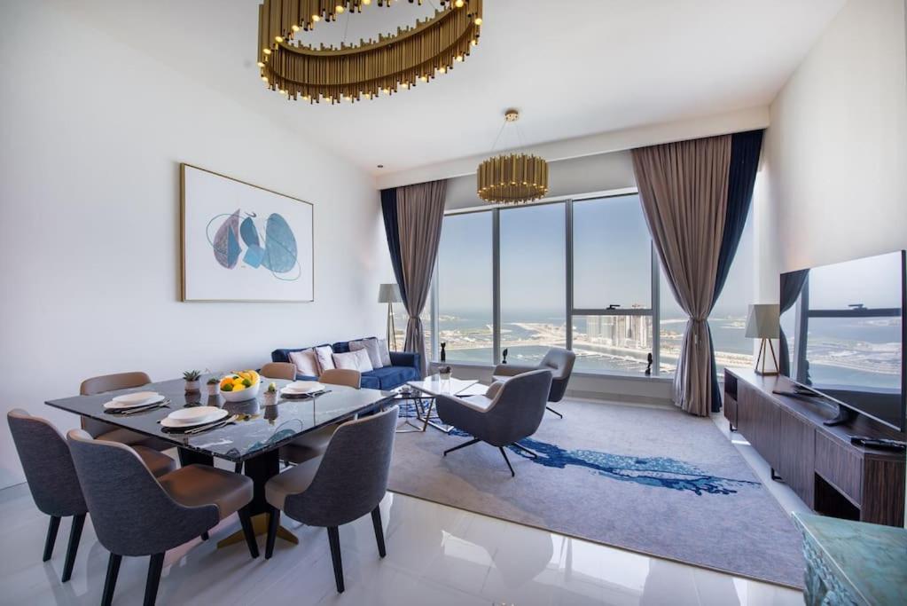 a dining room and living room with a table and chairs at Stunning Views & Palm Marina Views & 39th floor in Dubai