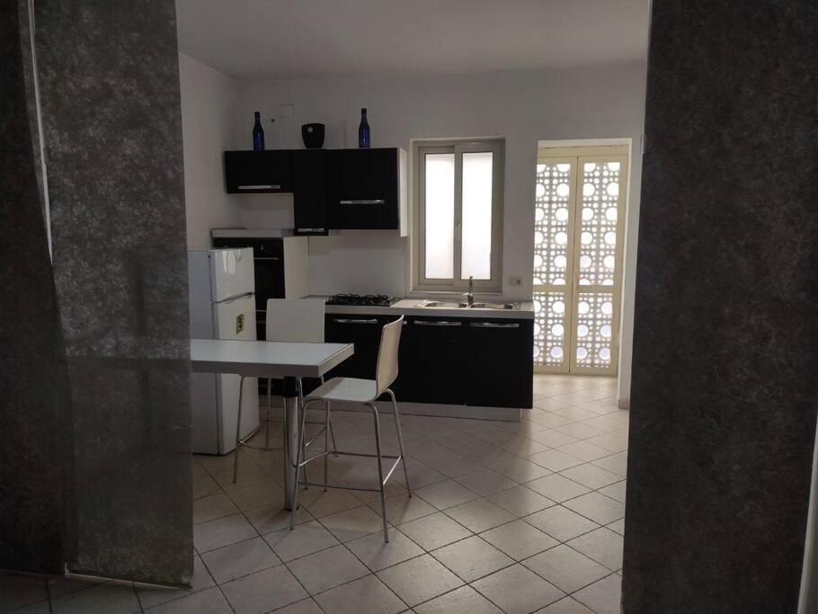 a kitchen with a table and a stove and refrigerator at antohouse intero appartamento R5883 in Quartucciu