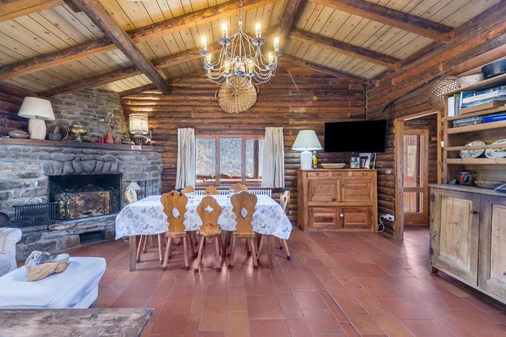 a dining room with a table and a fireplace at Chalet complet in Antey-Saint-André