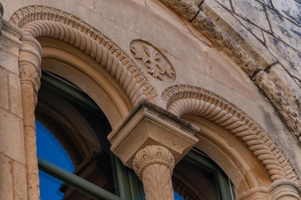 an archway on the side of a building at Palazzo Bifora in Mdina
