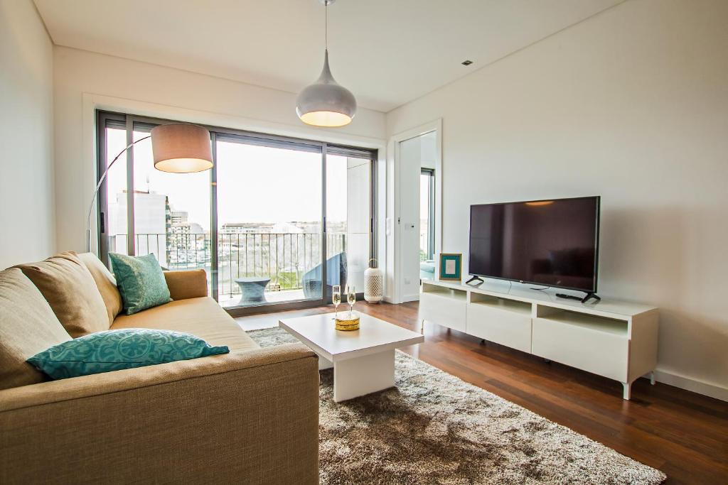 a living room with a couch and a flat screen tv at Tower View - Apartamento superior no centro de Aveiro in Aveiro