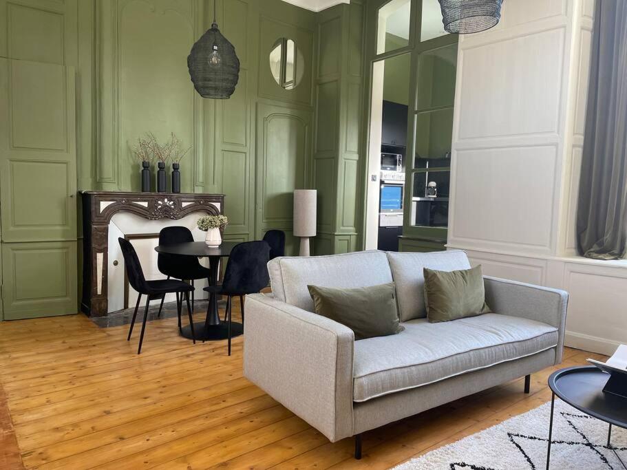 een woonkamer met een bank en een tafel bij Appartement 2pers «Le Parisien » in Saint-Omer