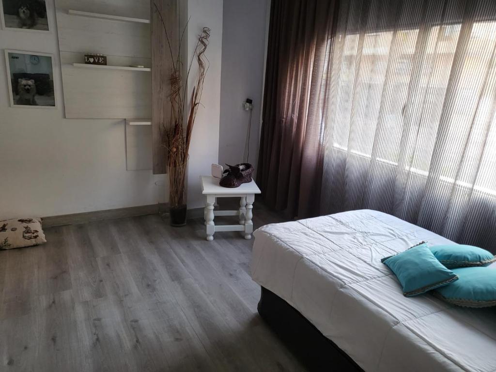 um quarto com uma cama, uma mesa e uma janela em Casa Violeta em Aguadulce