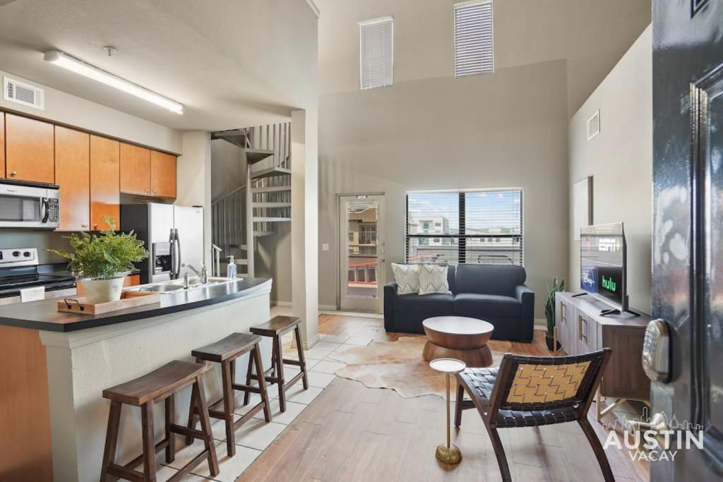 a kitchen and living room with a couch and a table at Balcony Views and Ideal West Campus Austin Location in Austin