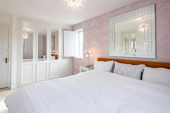 ein Schlafzimmer mit einem großen weißen Bett und einem Spiegel in der Unterkunft Luxury superking OR standard OR budget rooms in Newhaven