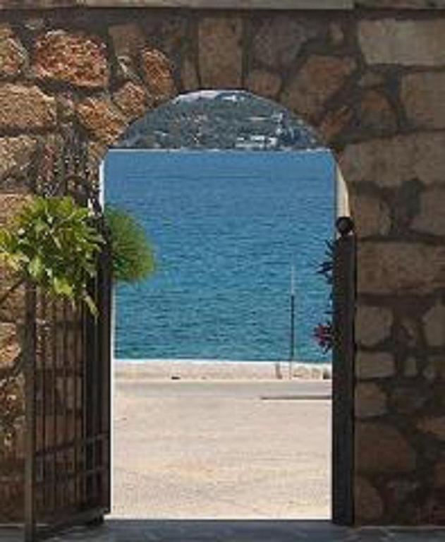 an open gate with a view of the water at Kastro Hotel in Spetses
