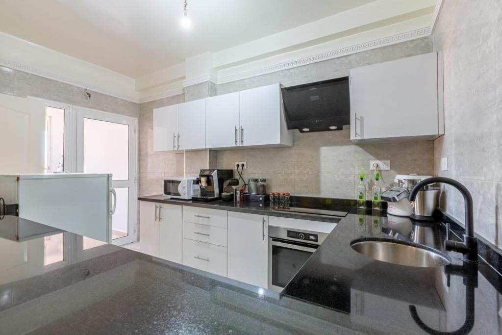 a kitchen with white cabinets and a sink at Appartement 2 chambres in Marrakesh