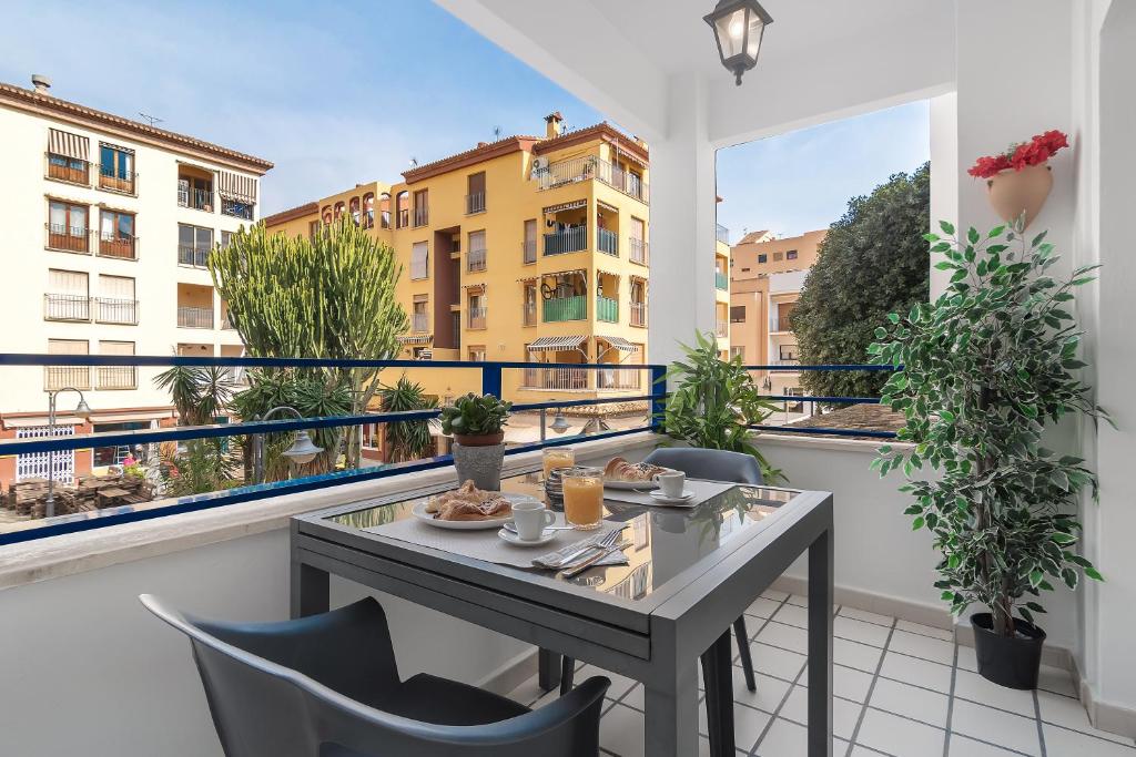a balcony with a table and chairs and a view of buildings at Apartamento mediterráneo en el alma de Moraira in Moraira