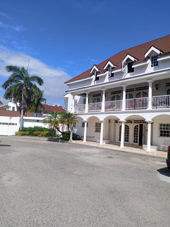 ein großes weißes Gebäude mit einer Palme und einer Straße in der Unterkunft Seacastles in Montego Bay