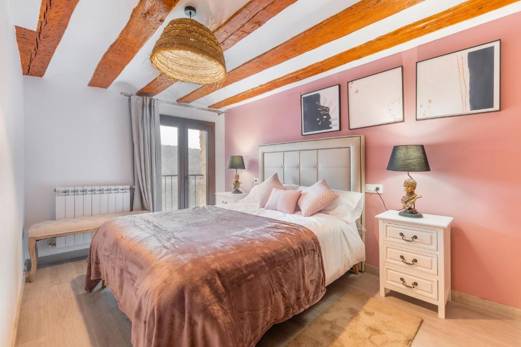 sypialnia z dużym łóżkiem i różowymi ścianami w obiekcie Casas Algarra Rural 