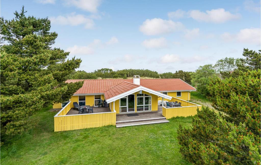 ブラーバンドにあるAmazing Home In Blvand With 4 Bedrooms, Sauna And Indoor Swimming Poolの庭にデッキがある黄色い家