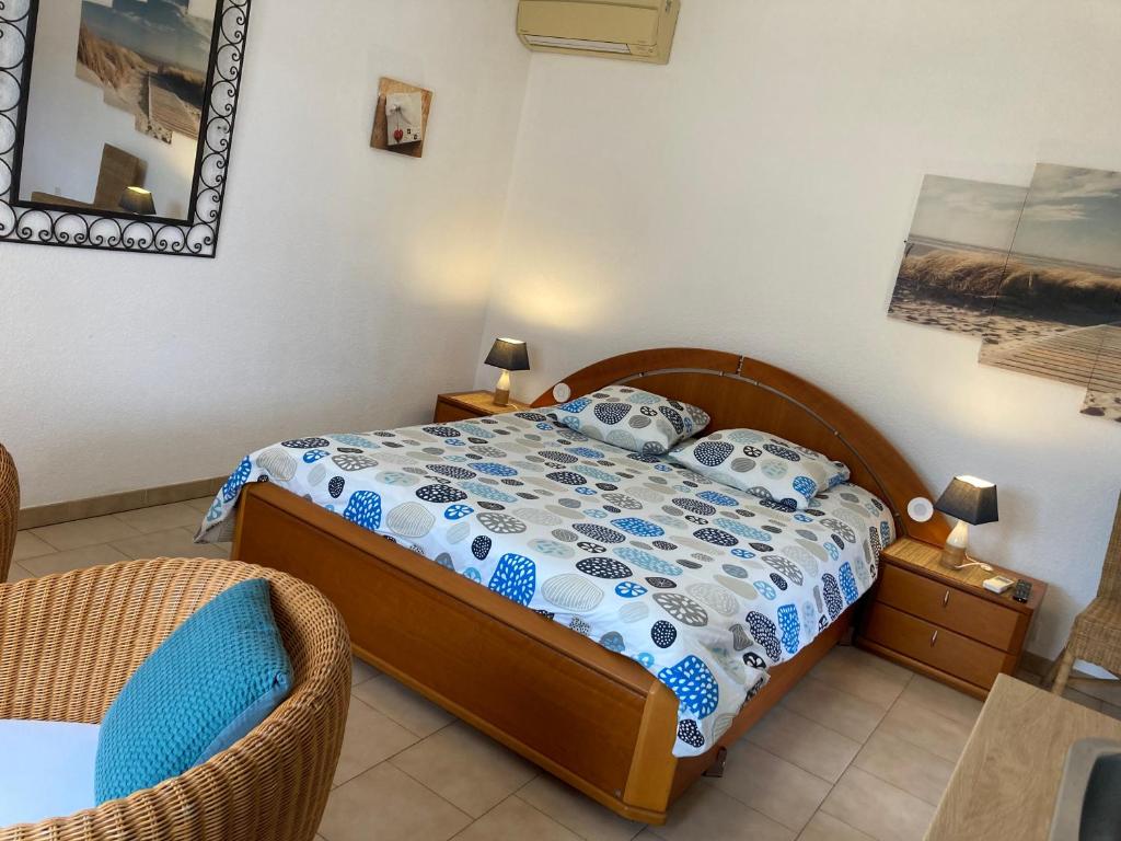 ein kleines Schlafzimmer mit einem Bett und einem Stuhl in der Unterkunft Les Bougainvillées de Camargue in Villetelle