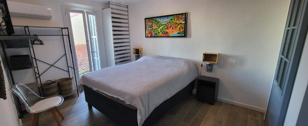 - une petite chambre avec un lit et une photo sur le mur dans l'établissement Superbe T2, Vieux Port, Hyper centre Ajaccio, à Ajaccio