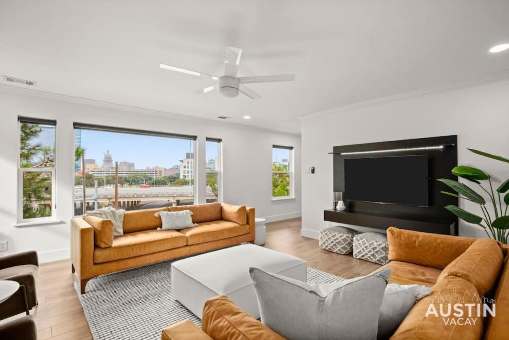 a living room with two couches and a television at Capitol View DT w Elevator with Free Swim Club Access in Austin