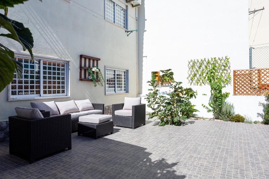 a patio with couches and chairs in a courtyard at Caparica Sun Beach Villa in Charneca