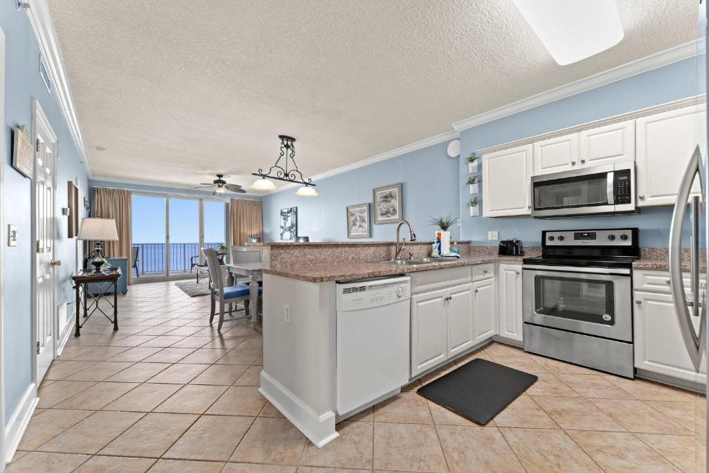 a kitchen with white appliances and a dining room at Twin Palms 1705 in Panama City Beach