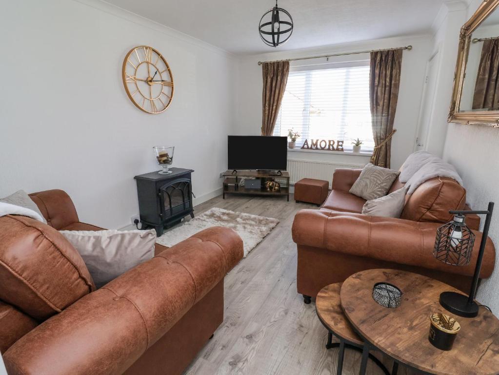 a living room with two couches and a table at 2 Rowan Walk in Hornsea