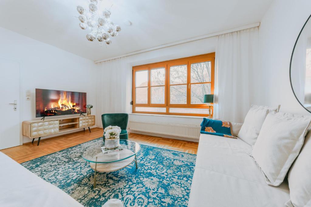 a living room with a white couch and a tv at Haus mit Donaublick, Terrasse und Garten in Dürnstein