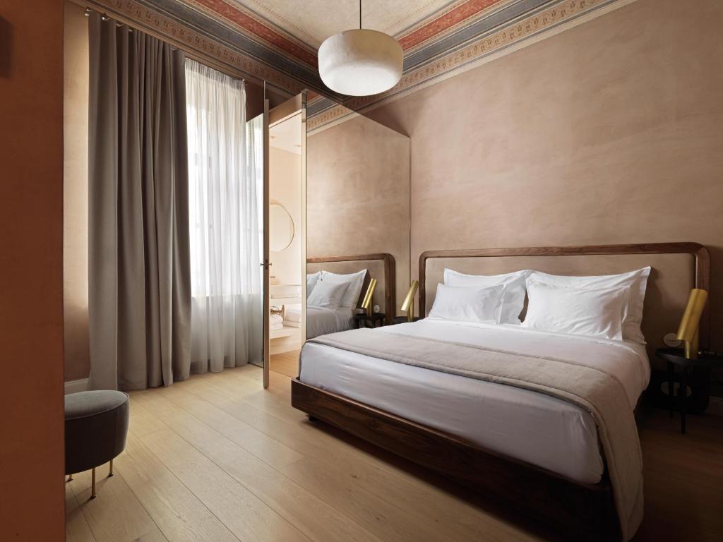 um quarto com uma cama grande e almofadas brancas em Monument em Atenas