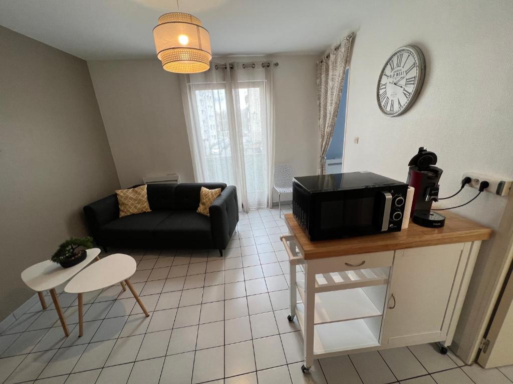 - un salon avec un canapé et une table avec un four micro-ondes dans l'établissement T1 bis cosy-proche campus et stade des alpes, à Grenoble