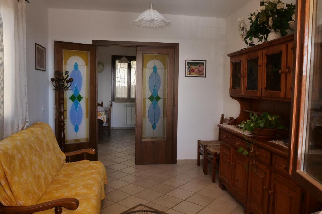 een woonkamer met een stoel en een deur bij Casa vacanza Riparbella in Riparbella