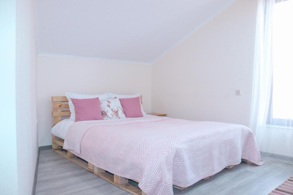 a bedroom with a bed with pink and white sheets at Taniq Guesthouse 