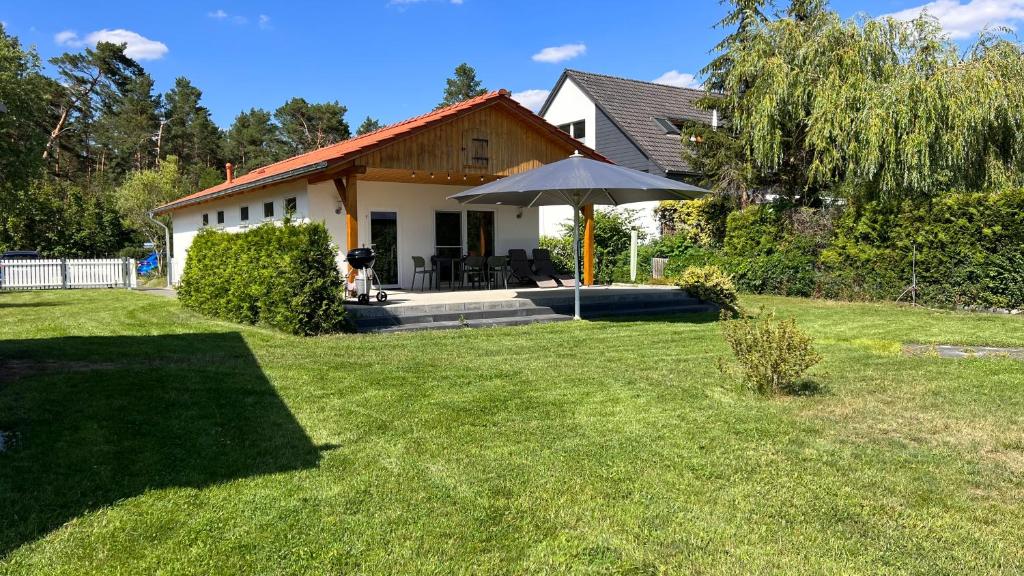 une maison avec un parasol dans une cour dans l'établissement Kleemann´s Apartment****, à Zossen