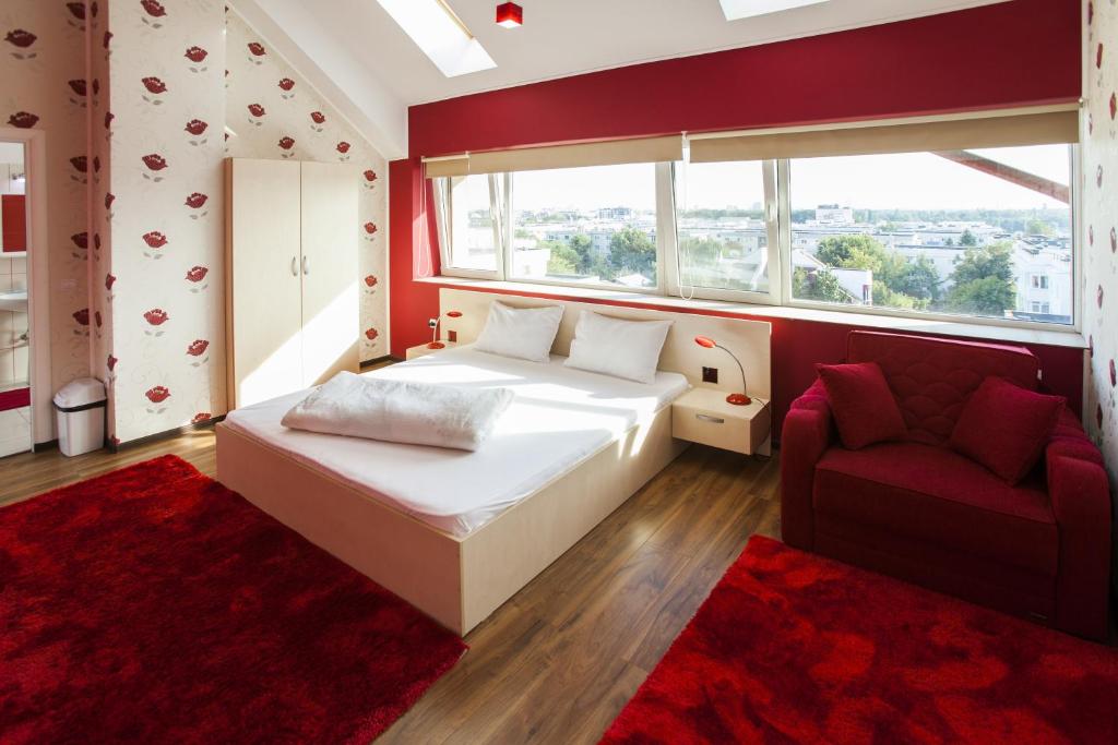 ブカレストにあるHotel La Gilのベッドルーム1室(ベッド1台、ソファ、窓付)