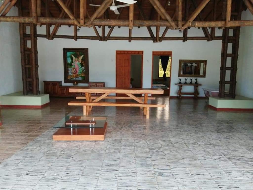 een grote kamer met een houten tafel in een gebouw bij FINCA HOTEL BUENOS AIRES DORADAL in Puerto Triunfo