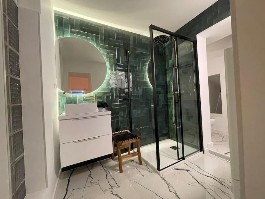 uma casa de banho com um chuveiro, um lavatório e um espelho. em T2 neuf avec Parking et terrasse em Toulon