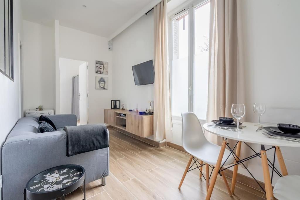 sala de estar con sofá y mesa en Appartement cosy 30 m² proche RER B - 4 min à pied, en Aulnay-sous-Bois
