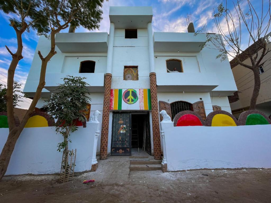a white building with a flag in front of it at Peace & Freedom Guesthouse & Restaurant in Luxor