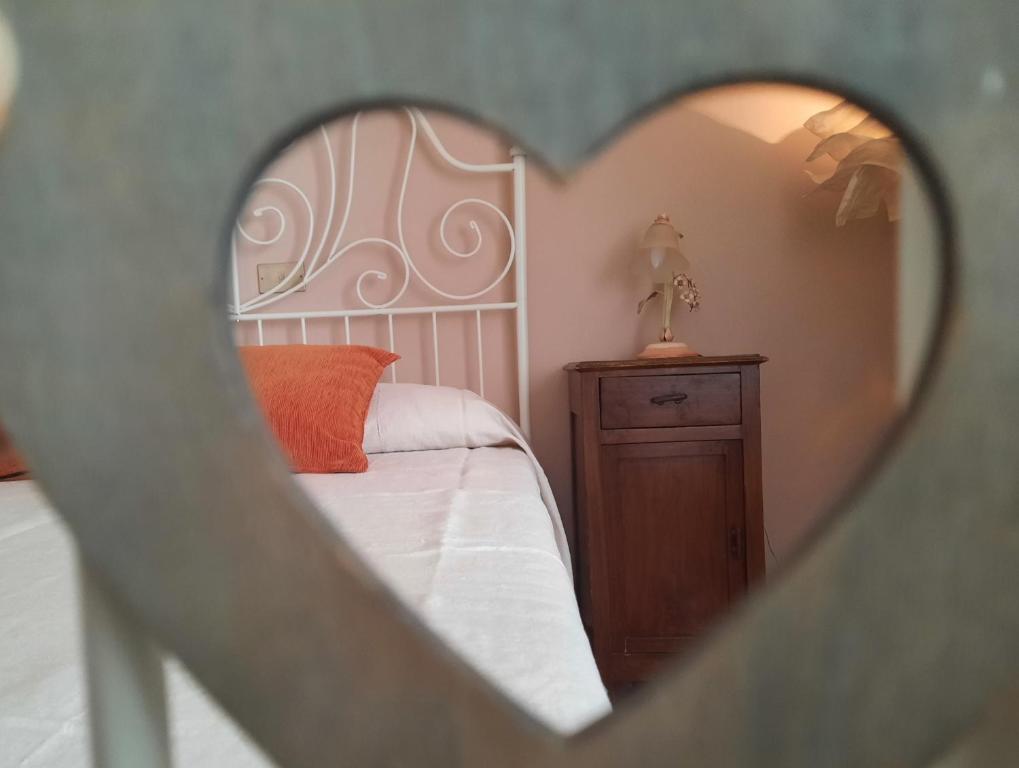 SassofortinoにあるLa Casa del Soleの白いベッドと木製キャビネット付きのベッドルーム1室が備わります。