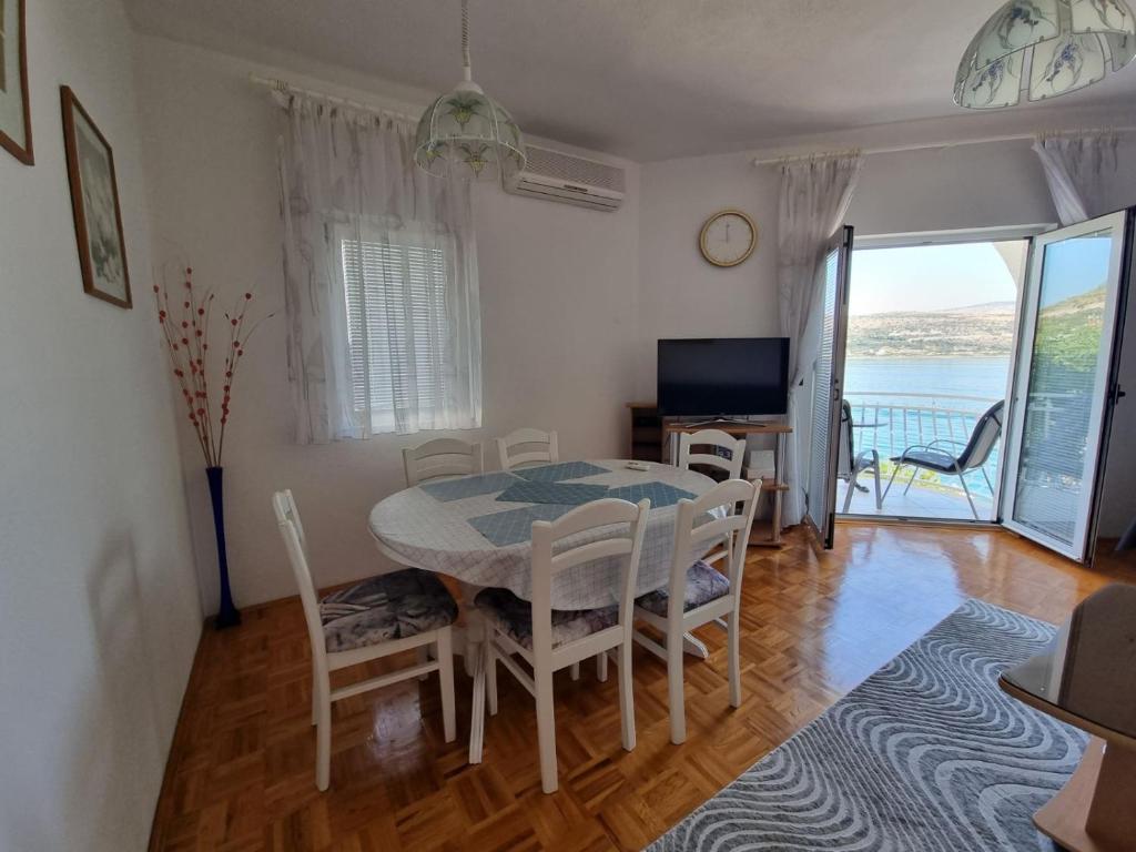 comedor con mesa, sillas y ventana en Apartment Matej, en Trogir