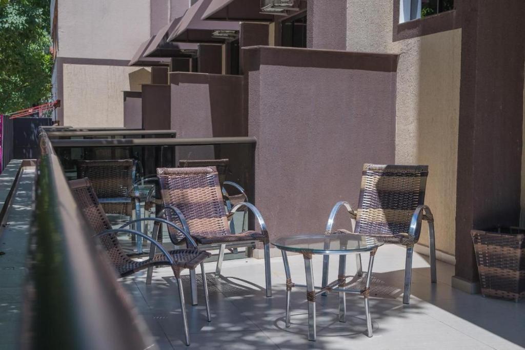 a group of chairs and a table on a patio at Hotel Iguaçu Centro in Foz do Iguaçu