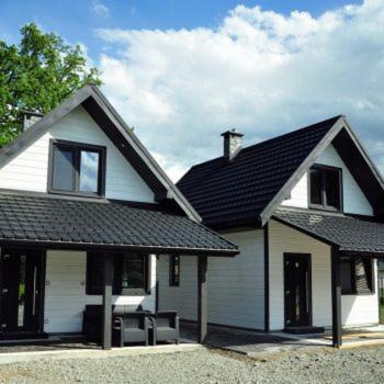 a white house with a black roof at Domki u Biesiady in Lesko