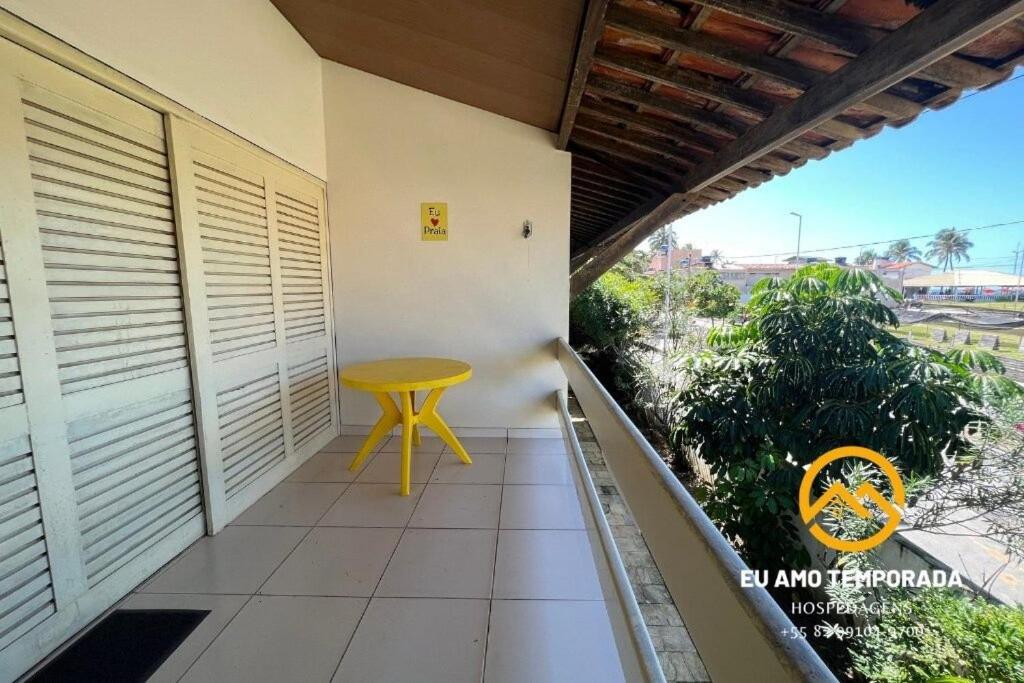 a small yellow table on the balcony of a house at @euamotemporada Cumaru APT 207 - 100m da Praia in Marechal Deodoro