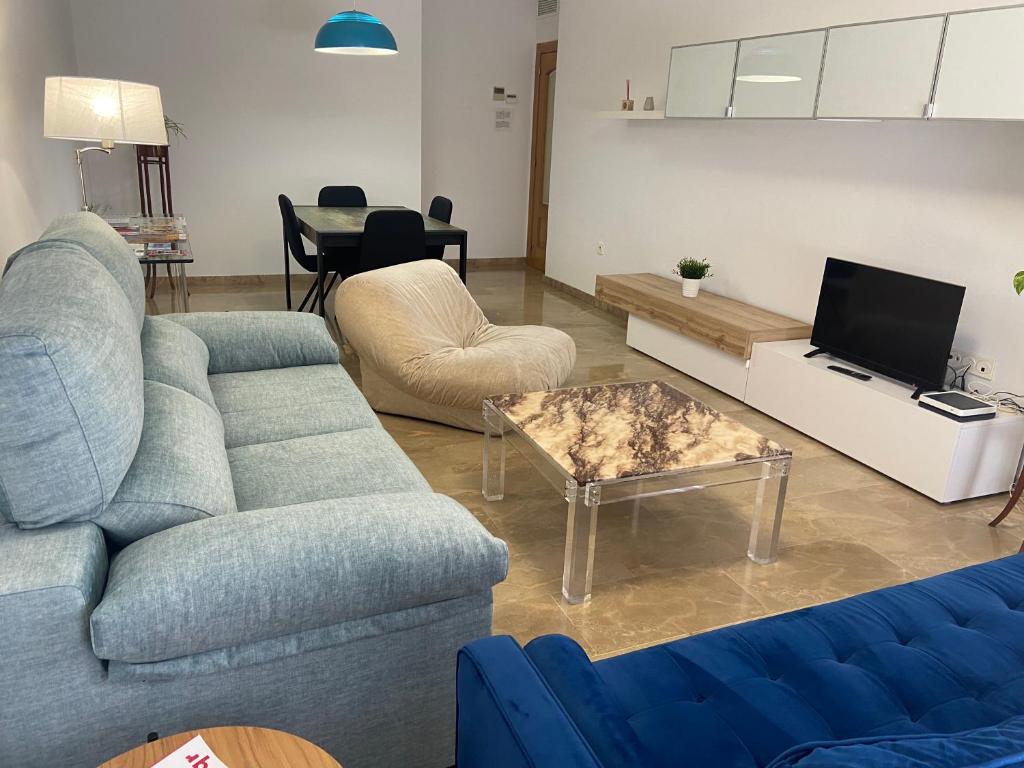 a living room with a blue couch and a table at Apartamento Pandora, ideal para sentirte como en casa in Villena