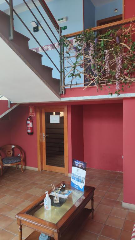 a living room with a table and a staircase at Pension Urola in Zumárraga