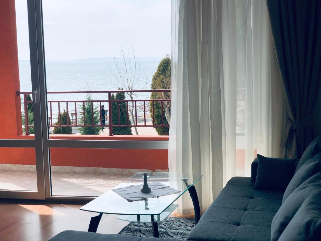 un soggiorno con divano e vista sull'oceano di Beautiful apartment right by the sea, Sveti Vlas a Sveti Vlas