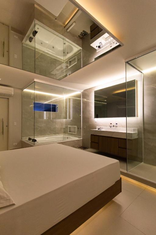 a bedroom with a large white bed and a bathroom at Uno Prime Motel - Av Aricanduva in São Paulo