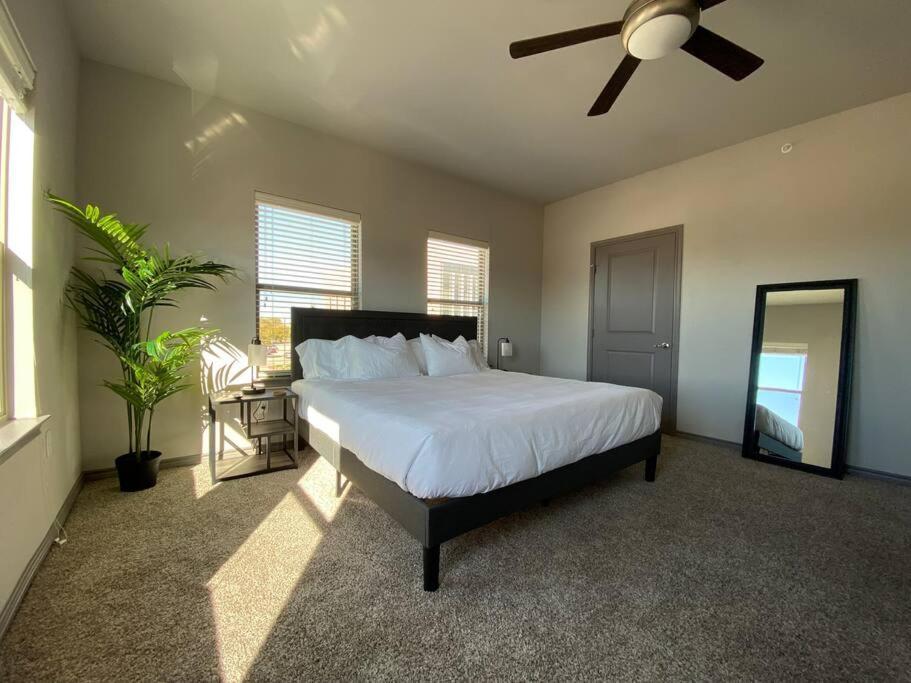 um quarto com uma cama e uma ventoinha de tecto em KING BEDS-Lg Apt-65 inch Roku-Walk to Food and Drinks em Fort Worth