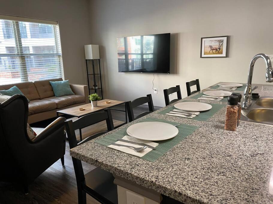 uma cozinha e sala de estar com uma mesa e um sofá em KING BEDS & Patio-65 inch Roku-Walk to Food and Drinks em Fort Worth