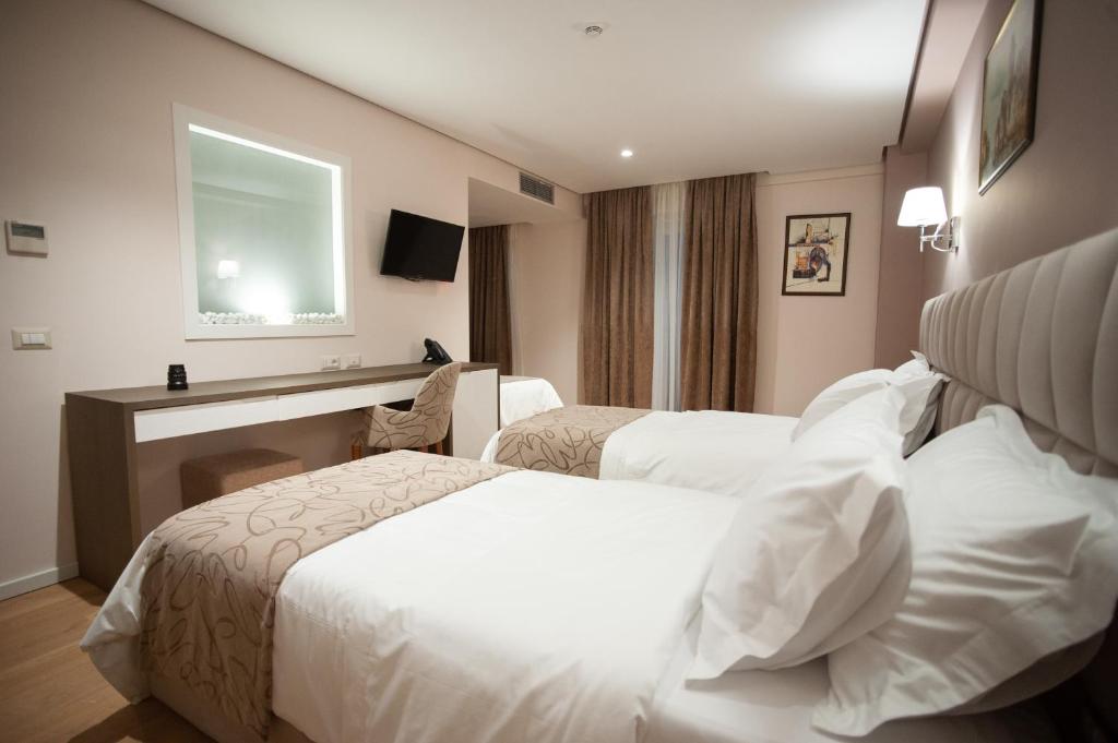 a hotel room with two beds and a window at Doanesia Premium Hotel & Spa in Tirana